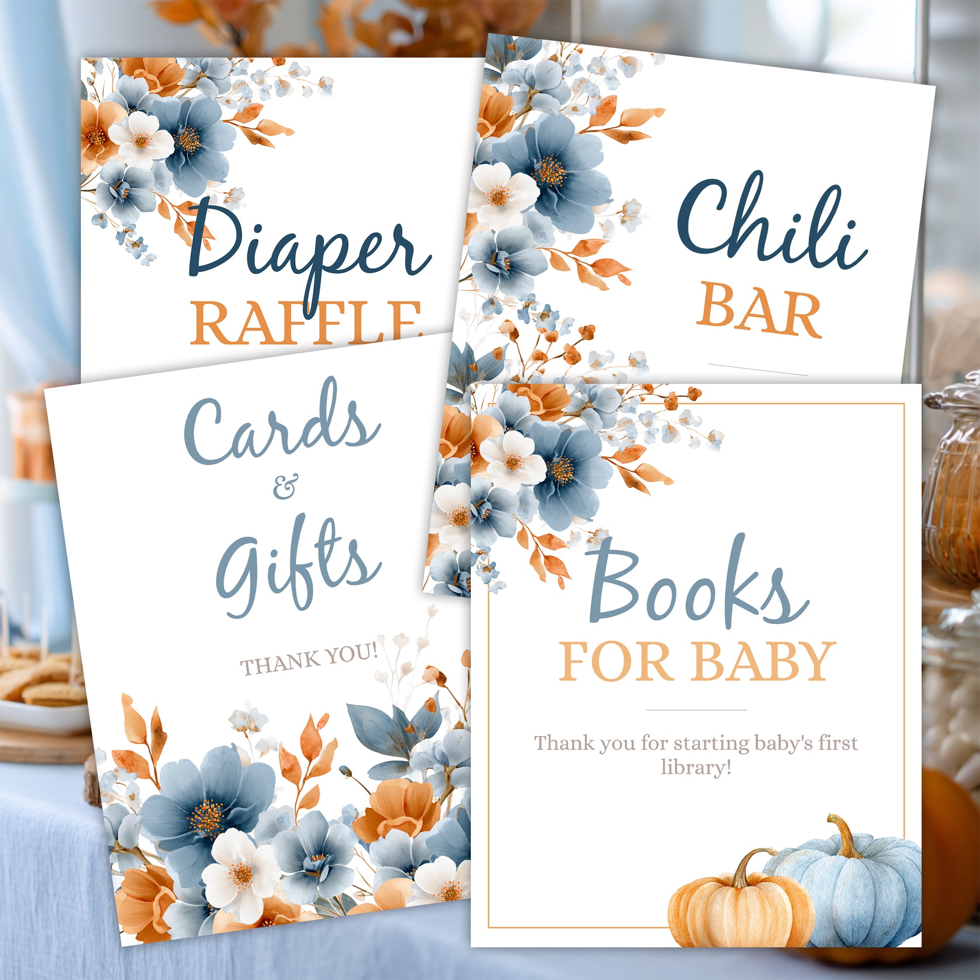 Baby shower table setup with printable floral signs including diaper raffle, books for baby, and cards and gifts signage